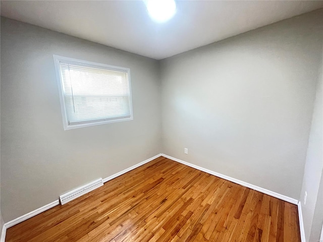 spare room with light wood-style flooring, visible vents, and baseboards