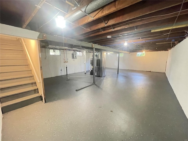 basement with heating unit and stairway