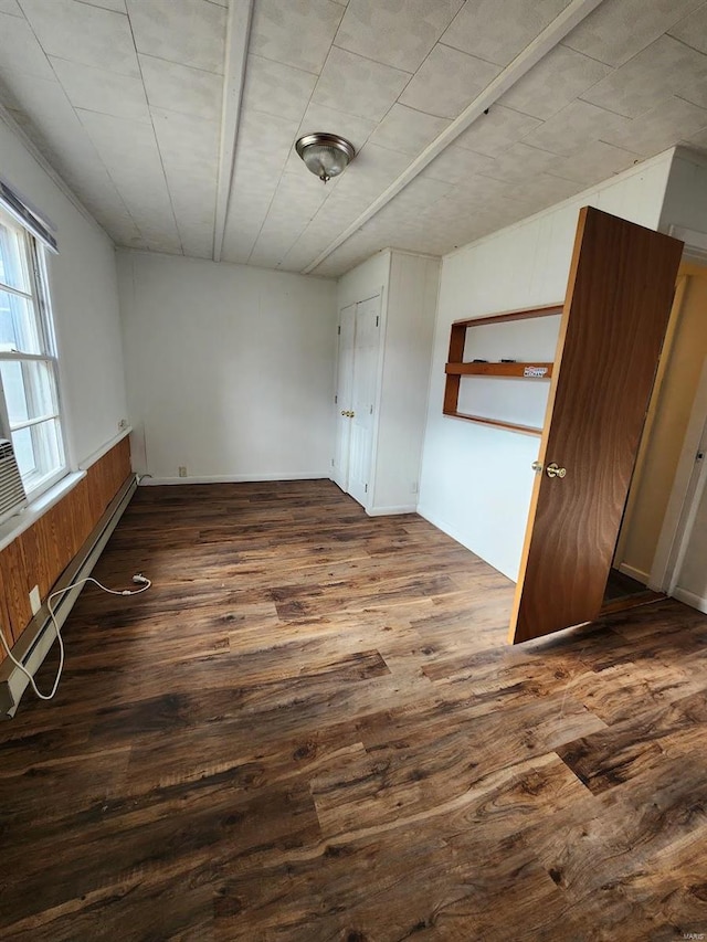 unfurnished bedroom featuring a baseboard radiator and dark hardwood / wood-style floors