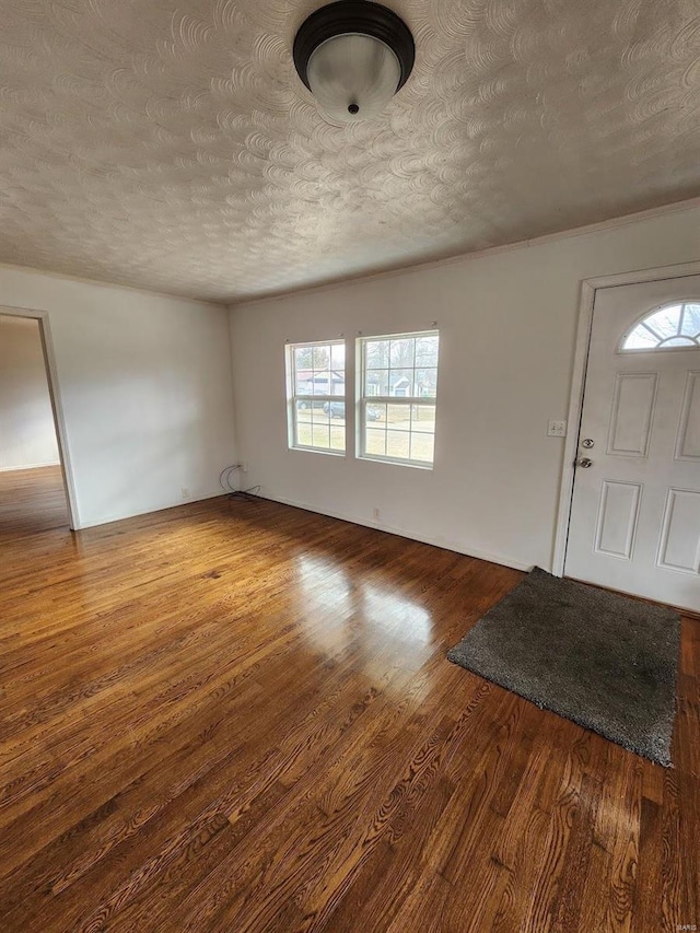 foyer entrance with a textured ceiling and dark hardwood / wood-style flooring