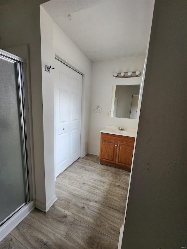 bathroom with vanity, an enclosed shower, and wood-type flooring