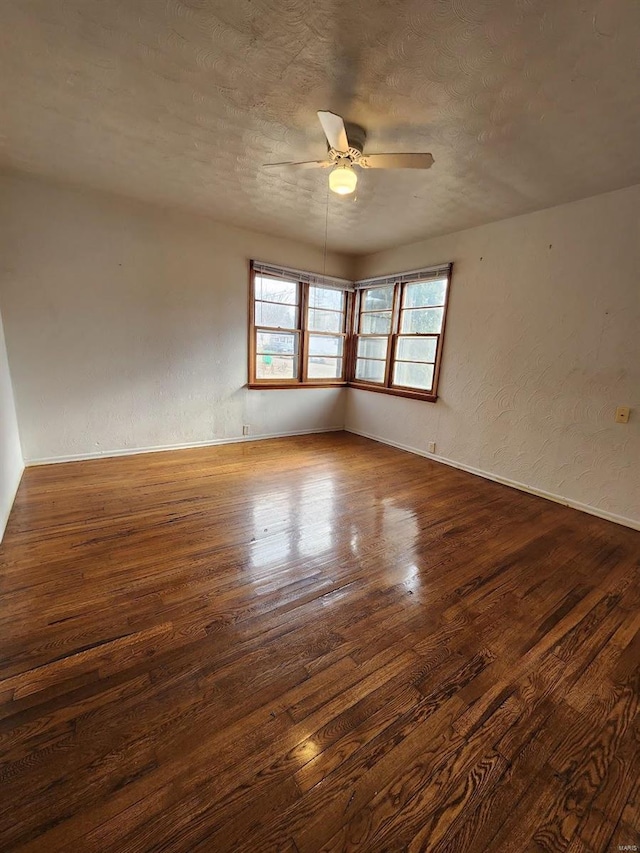 unfurnished room featuring ceiling fan, a textured ceiling, and dark hardwood / wood-style flooring