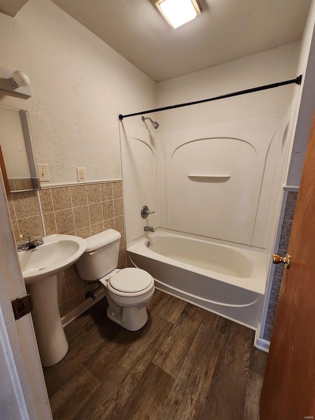 bathroom featuring tile walls, wood-type flooring, toilet, and shower / bath combination