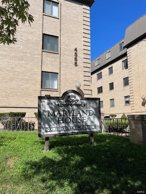 community sign featuring a lawn