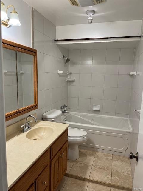full bathroom with vanity, toilet, tile walls, and tiled shower / bath