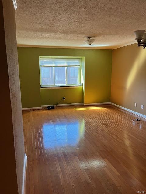 spare room with hardwood / wood-style flooring and a textured ceiling