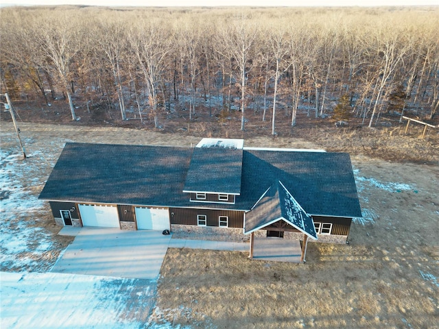 view of front of home with driveway, stone siding, and an attached garage