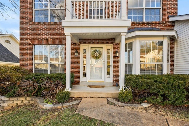 property entrance featuring brick siding and a balcony