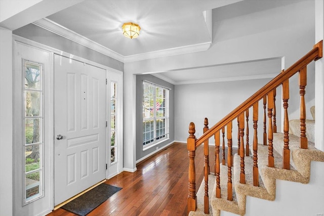 foyer with hardwood / wood-style flooring, stairs, baseboards, and crown molding