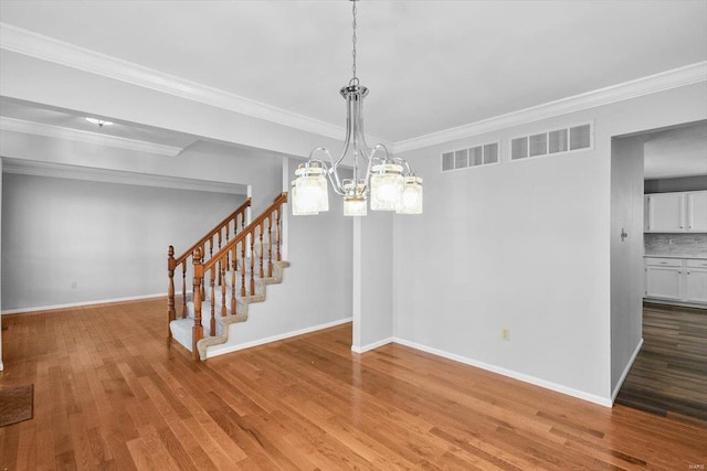 unfurnished dining area featuring stairway, wood finished floors, visible vents, and baseboards