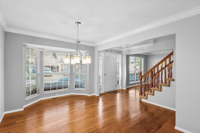 foyer featuring plenty of natural light, wood finished floors, and crown molding