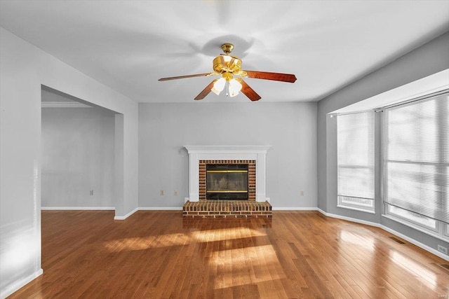 unfurnished living room featuring wood-type flooring, visible vents, a fireplace, and baseboards