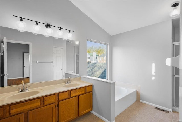 bathroom featuring vaulted ceiling, visible vents, a sink, and a bath