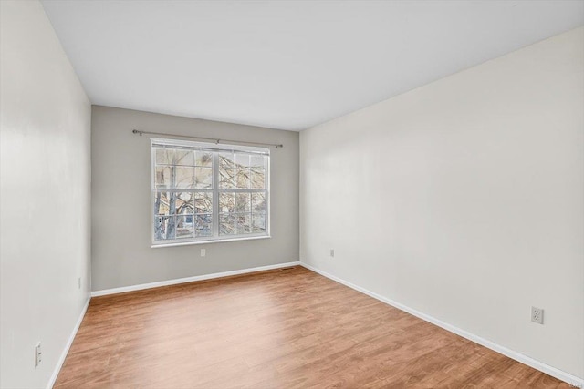 empty room featuring wood finished floors and baseboards