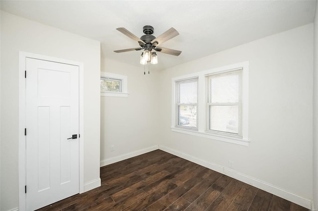 spare room with dark wood-style floors, baseboards, and a ceiling fan