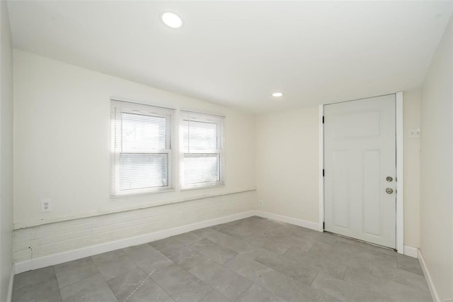 empty room featuring recessed lighting and baseboards