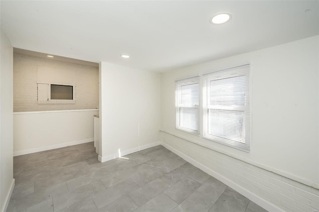 spare room featuring baseboards and recessed lighting