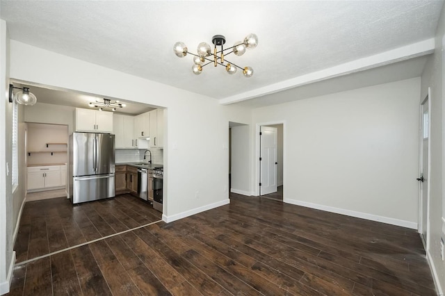 kitchen with a sink, baseboards, appliances with stainless steel finishes, decorative backsplash, and dark wood-style floors