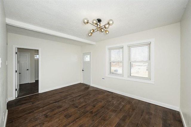 unfurnished room featuring beam ceiling, baseboards, a chandelier, and dark wood-type flooring