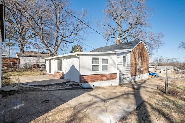 view of front of property with entry steps, fence, a patio, and brick siding