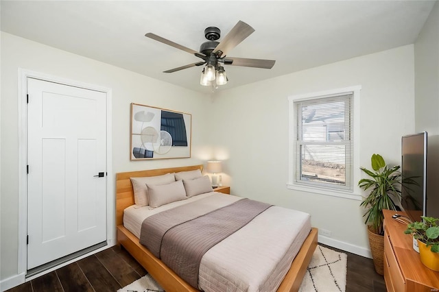 bedroom featuring a ceiling fan, dark wood-style flooring, and baseboards