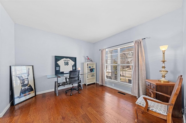 home office featuring baseboards, visible vents, and wood finished floors