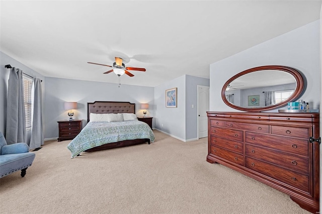 bedroom featuring light carpet, multiple windows, a ceiling fan, and baseboards