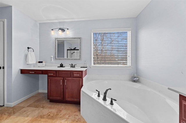 bathroom with vanity, baseboards, and a bath