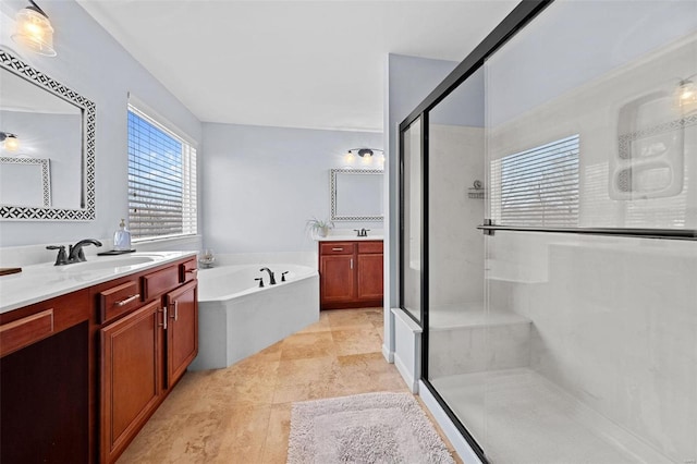 full bath with a stall shower, two vanities, a sink, and a garden tub