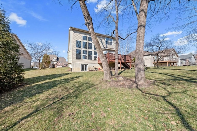 rear view of property featuring a lawn and a wooden deck