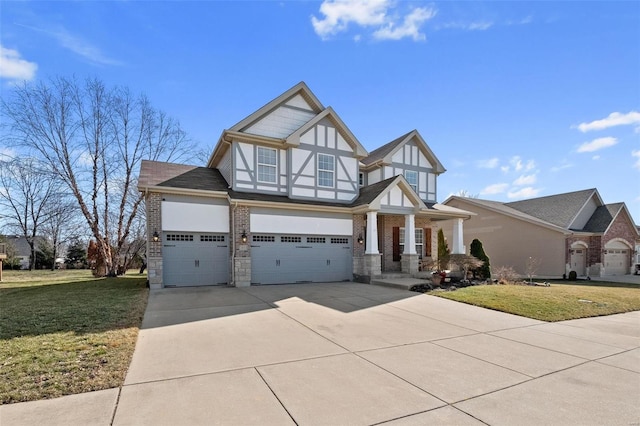 tudor house featuring a garage, a front yard, and driveway