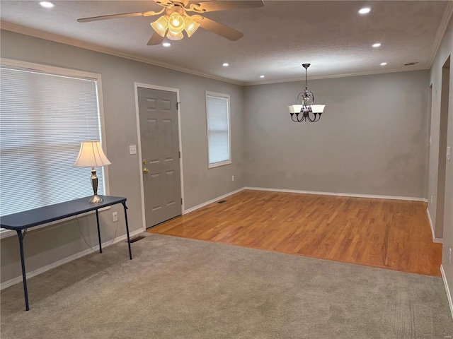 entrance foyer featuring crown molding, light colored carpet, and ceiling fan with notable chandelier