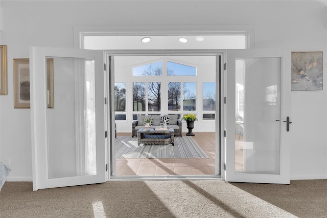 entryway with lofted ceiling, carpet floors, and french doors