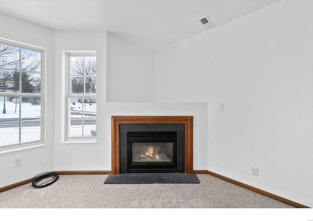 details featuring a glass covered fireplace, carpet flooring, visible vents, and baseboards