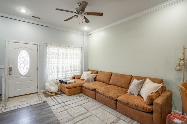 living room featuring ceiling fan, ornamental molding, and light hardwood / wood-style floors