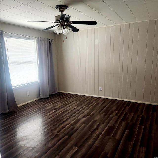 unfurnished room with dark wood-style floors, baseboards, and a ceiling fan