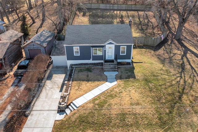 view of front of home featuring roof with shingles, a front lawn, and fence