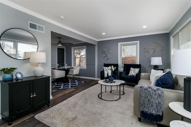 living room featuring ornamental molding, dark wood-type flooring, and ceiling fan