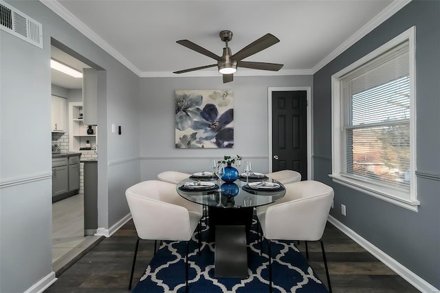 dining space featuring crown molding, dark wood-type flooring, and ceiling fan