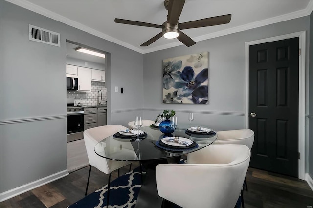 dining room featuring sink, ornamental molding, dark hardwood / wood-style floors, and ceiling fan