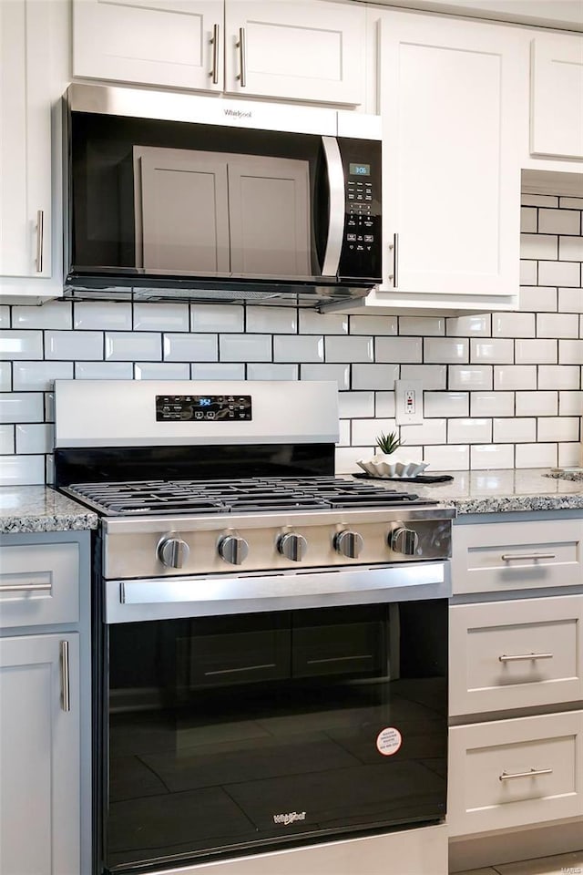 kitchen with white cabinetry, light stone counters, tasteful backsplash, and stainless steel appliances