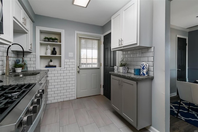 kitchen featuring white cabinetry, dark stone counters, and sink