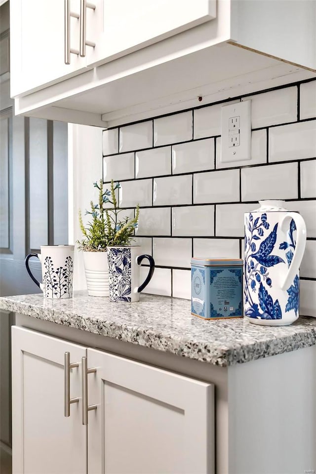 details with white cabinetry and light stone counters