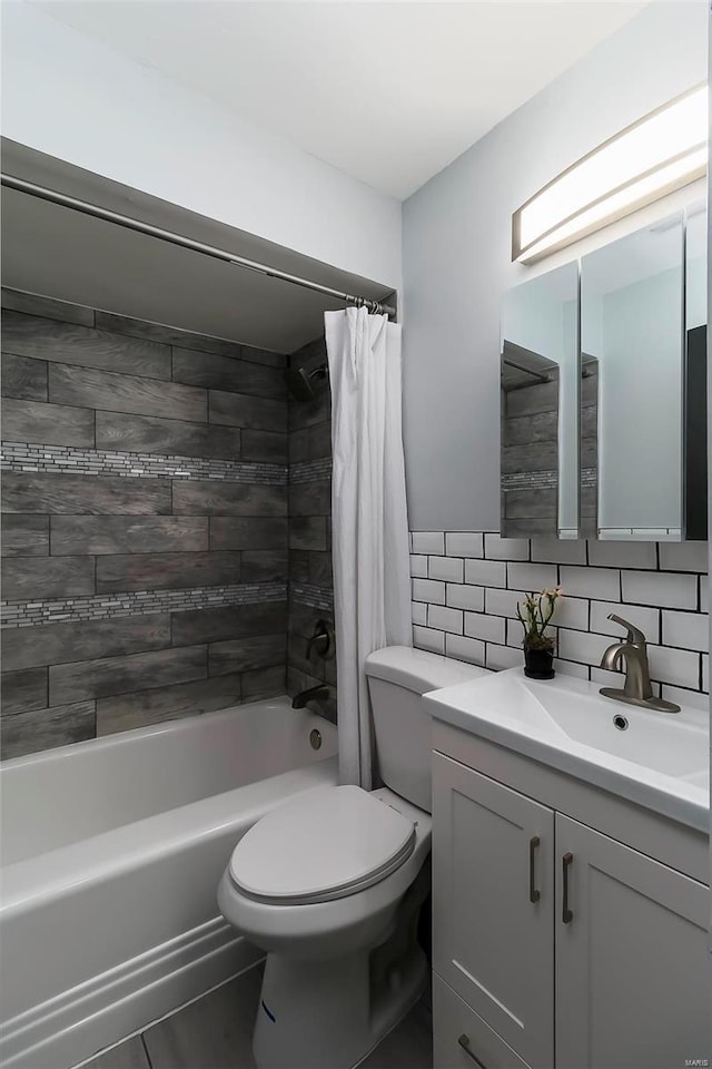 full bathroom with tile walls, shower / bath combination with curtain, decorative backsplash, vanity, and toilet