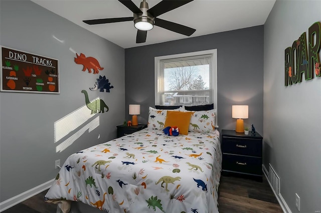 bedroom with dark hardwood / wood-style flooring and ceiling fan