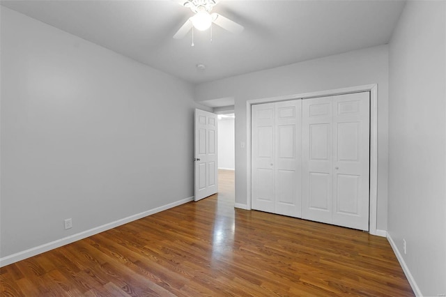 unfurnished bedroom with hardwood / wood-style floors, ceiling fan, and a closet