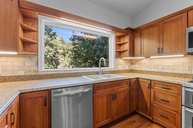 kitchen featuring appliances with stainless steel finishes, sink, hardwood / wood-style floors, and backsplash