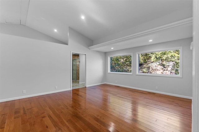 empty room with hardwood / wood-style flooring and lofted ceiling