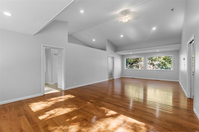 unfurnished living room with wood-type flooring and high vaulted ceiling