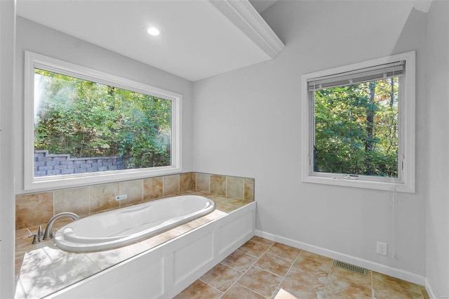 bathroom with plenty of natural light, tile patterned floors, and a tub